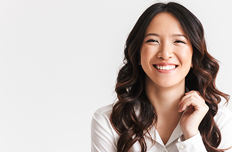 Portrait of gorgeous asian woman with long dark hair laughing at camera with beautiful smile, isolated over white background in studio