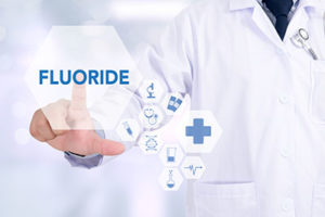 fluoride treatments tx, doctor in front of a chemical graphic of fluoride