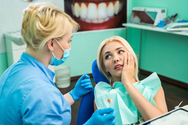 woman in dentist chair learning what is a dental emergency