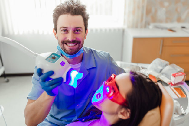 dentist smiling showing teeth whitening options