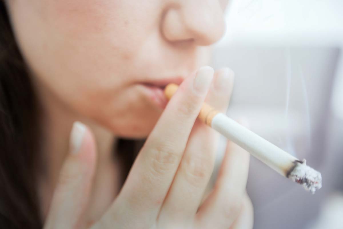 woman smoking showing causes of receding gums