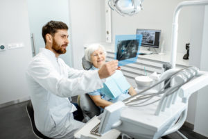 doctor prepares elderly patient for a root canal treatment 