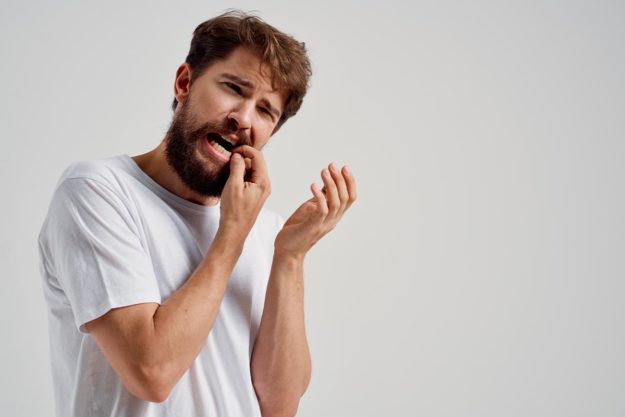 abscessed-tooth man struggles with an abscessed tooth